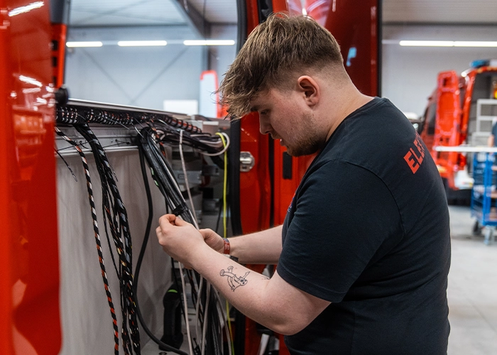 Mitarbeiter arbeitet an der Verkabelung eines Einsatzfahrzeuges